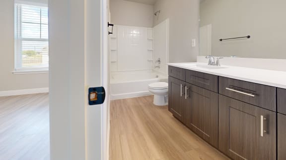 a bathroom with wooden flooring and a toilet and sink