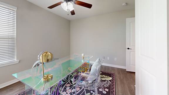 A glass table with a gold faucet and a chair with a white cushion.