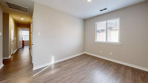 A room with a window and wooden floors.