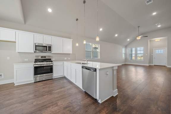 A spacious kitchen with white cabinets and stainless steel appliances.