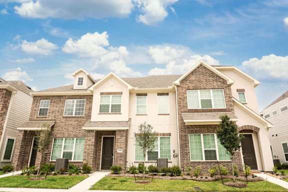 A large, well-maintained house with a front yard and landscaping.