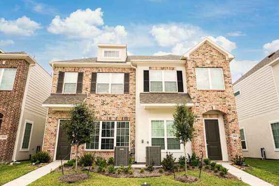 A brick house with a sign that says "Pinecrest Estates" on it.