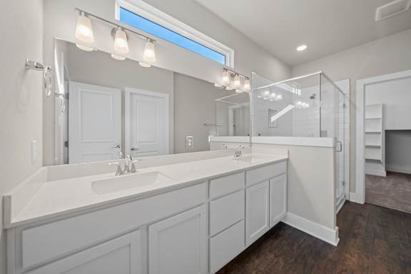 A bathroom with a large mirror and a white sink.