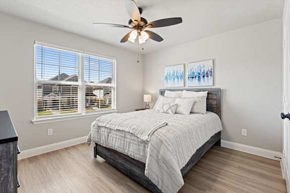 A bedroom with a large bed and a ceiling fan.