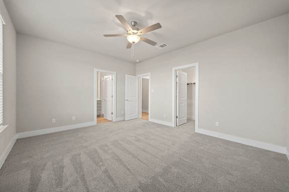 A room with a ceiling fan and carpeted floor.