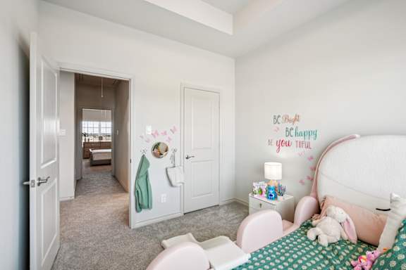 A child's bedroom with a bed, nightstand, and a wall decal that says "Be Pure, Be Happy, Be You Thing.".