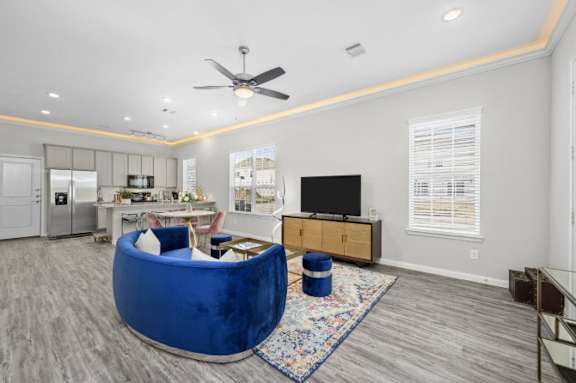 A living room with a blue chair and a television.