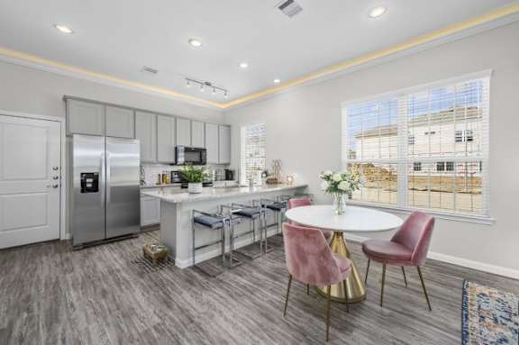 A modern kitchen with a dining table set for four.