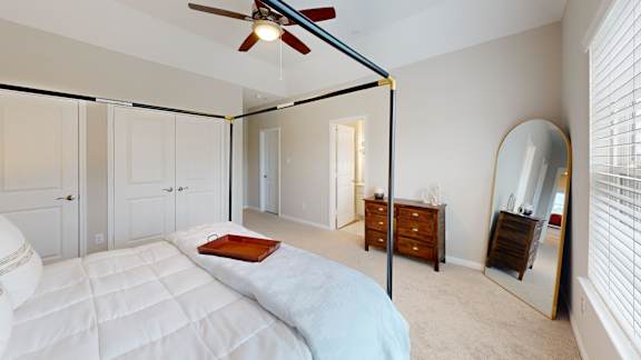 a bedroom with a large bed and a large mirror