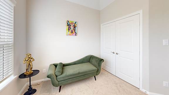a living room with a green couch and a white door