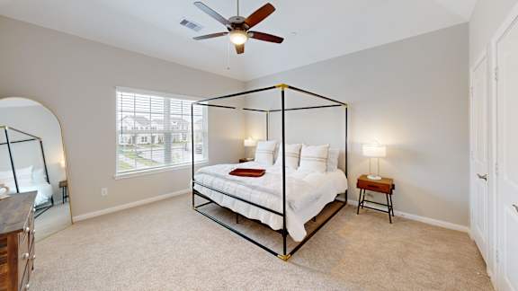 a bedroom with a large bed and a ceiling fan