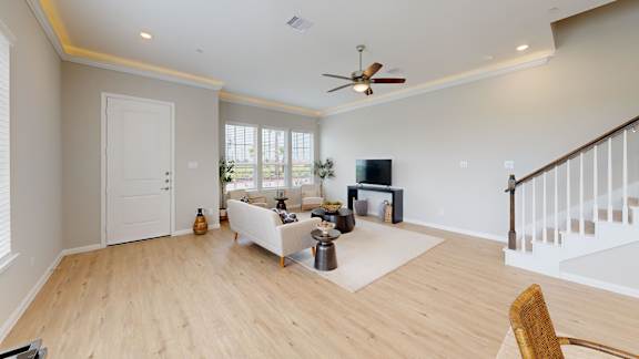 a living room with a couch and a chair and a ceiling fan
