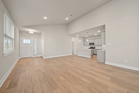 A spacious room with wooden flooring and white walls.