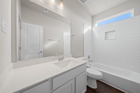 A white bathroom with a toilet, sink, and bathtub.
