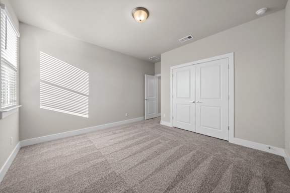 A room with a carpeted floor and a white door.