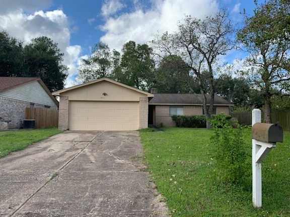 A house with a driveway and a mailbox in front.
