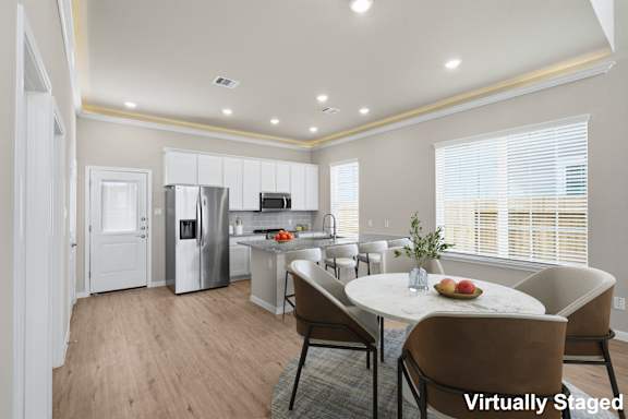 A modern kitchen with a dining table set for two.