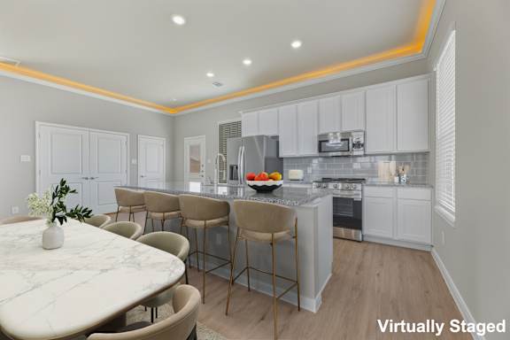 A kitchen with a table and chairs in front of it.