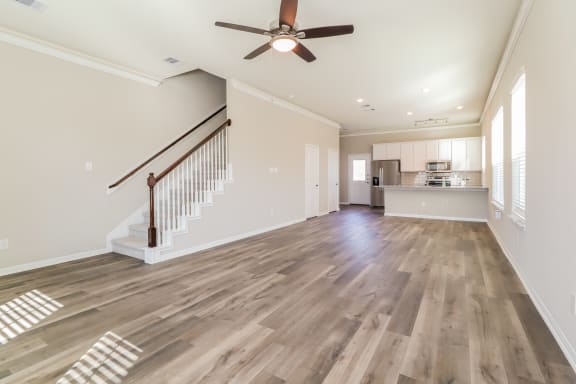 a living room with a staircase and a ceiling fan