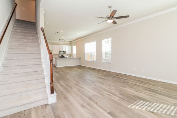 a living room with a staircase and a ceiling fan