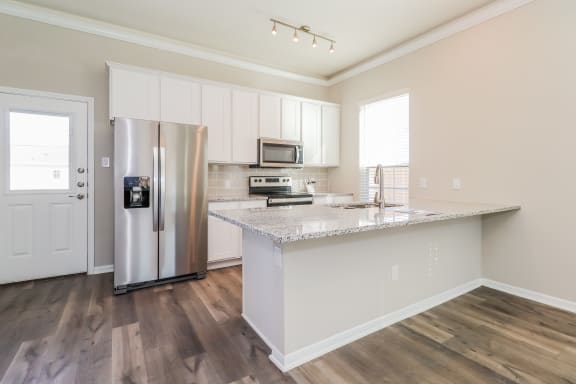 a kitchen with stainless steel appliances and a marble counter top