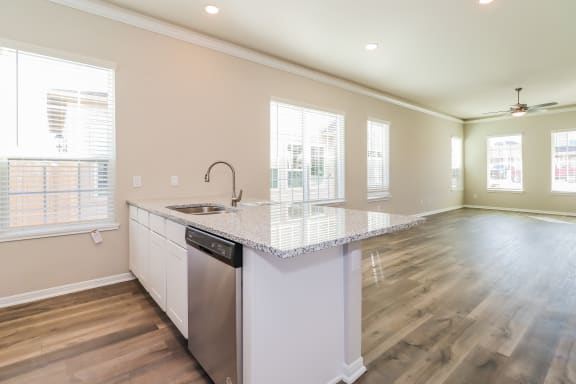 an empty kitchen with a counter top and a sink