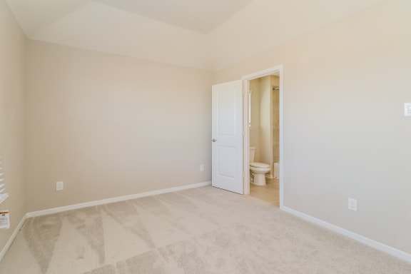 an empty room with a toilet and a door to a bathroom