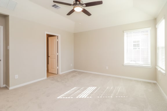 an empty living room with a ceiling fan