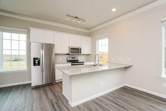 A kitchen with a refrigerator, microwave, and a countertop.