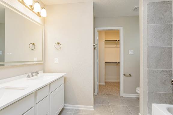 A bathroom with a white sink and a white door.