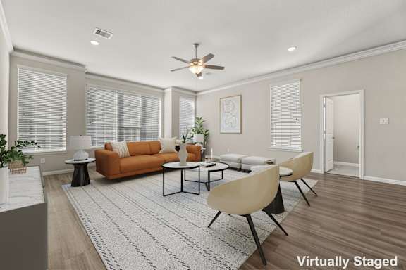 A living room with a brown sofa, a white table, and a rug.