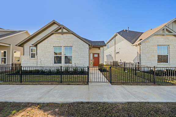 A row of houses with a black fence in front.