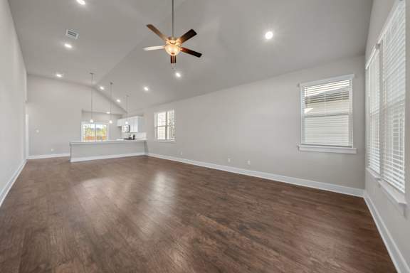 A room with a ceiling fan and wooden flooring.