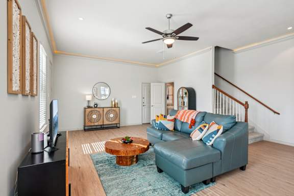 A living room with a blue couch and a wooden coffee table.