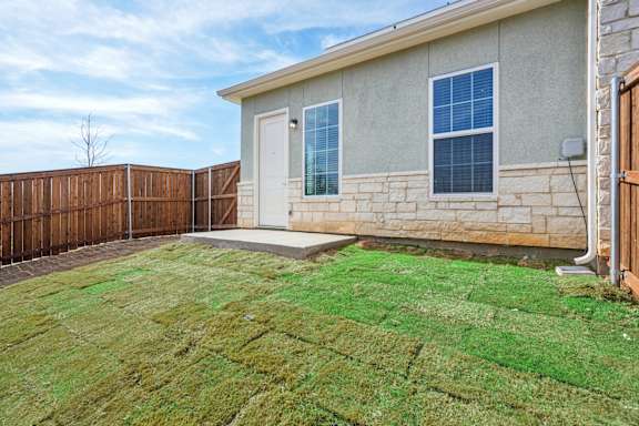 A house with a brown fence and a green lawn.