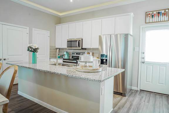 A kitchen with a countertop and a refrigerator.