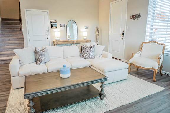 A living room with a white couch and a wooden coffee table.