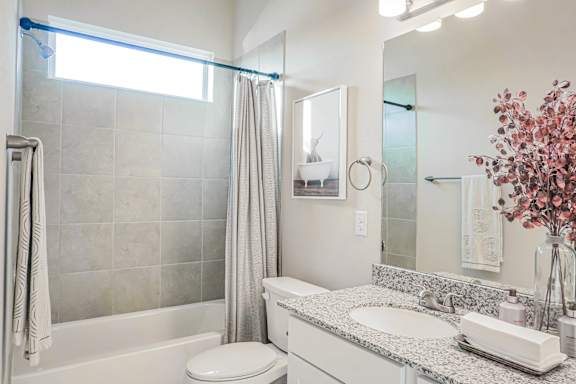 A bathroom with a toilet, sink, and shower.