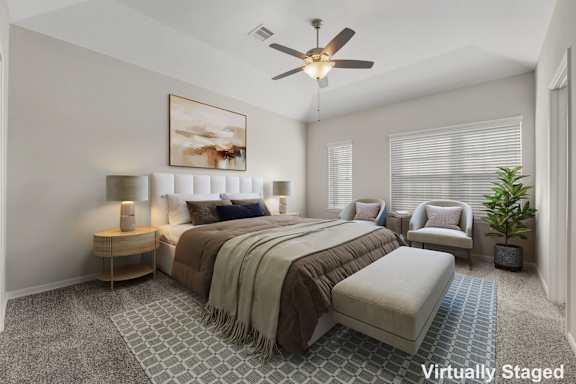 A bedroom with a large bed, a ceiling fan, and a painting on the wall.