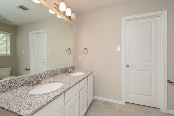 Bathroom with granite countertops and double vanity  at Pradera Oaks, Bonney, TX, 77583