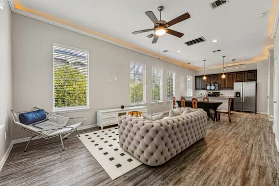 A modern living room with a grey tufted sofa and a wooden floor.