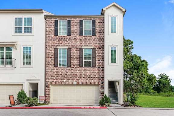 A two-story house with a brick facade and white trim.