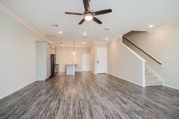 A spacious room with a ceiling fan and light fixture.