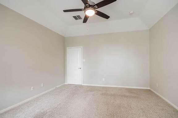 A room with a ceiling fan and carpeted floor.