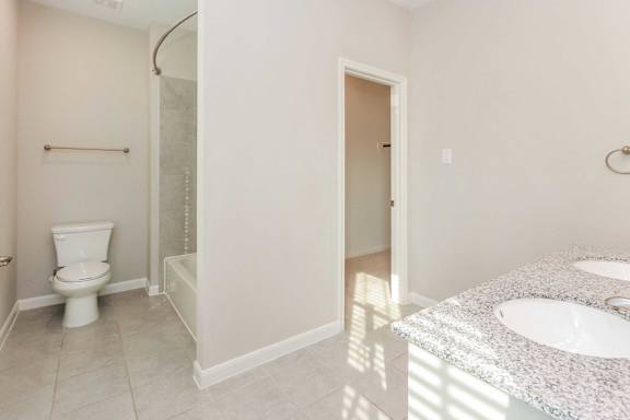A bathroom with a toilet, sink, and shower.