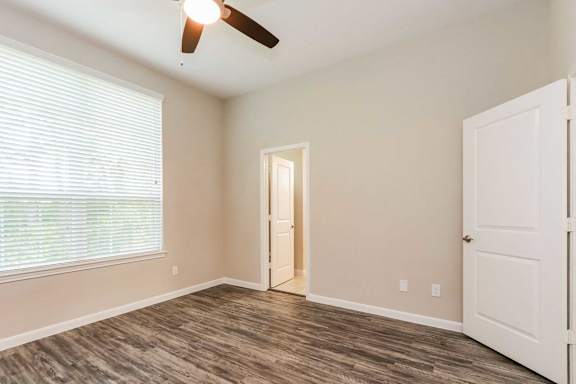 A room with a ceiling fan and a door.