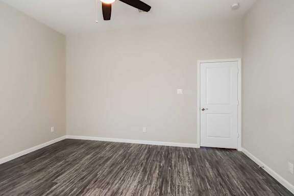 A room with a wooden floor and a ceiling fan.