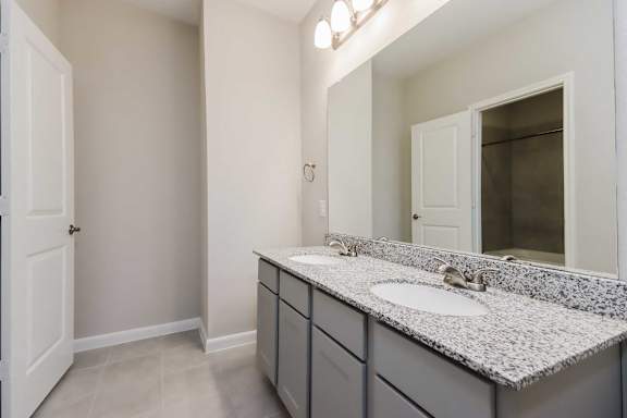 A bathroom with a sink, mirror, and cabinets.