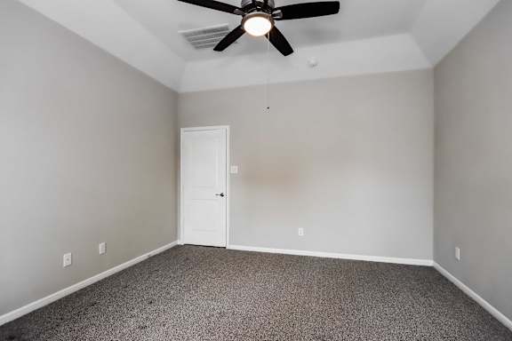 A room with a ceiling fan and carpeted floor.