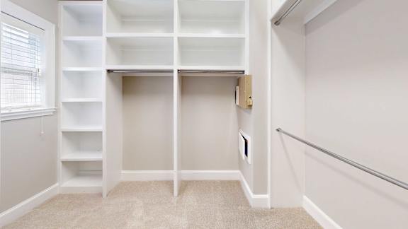 A white closet with shelves and a small door.